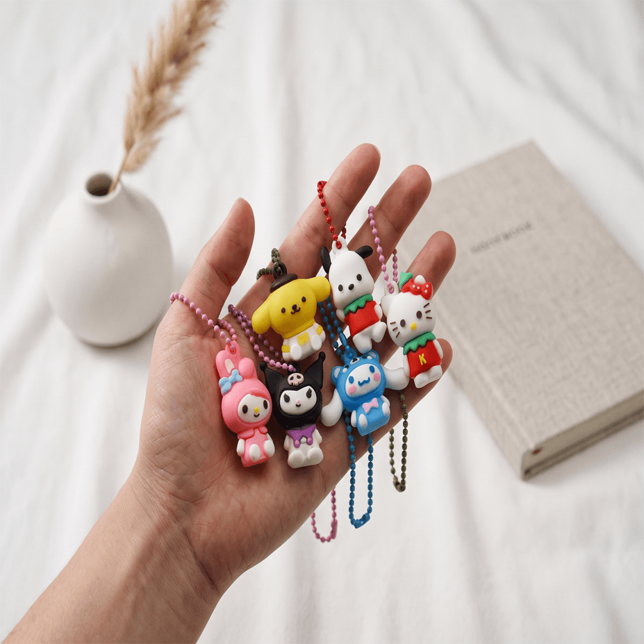 Sanrio Kawaii character keychain charms in hand — mini figure ball chain pendants for bags and backpacks